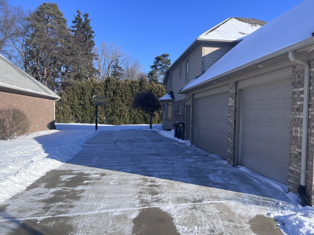 A fully plowed two-car driveway and garage after a Michigan snowfall