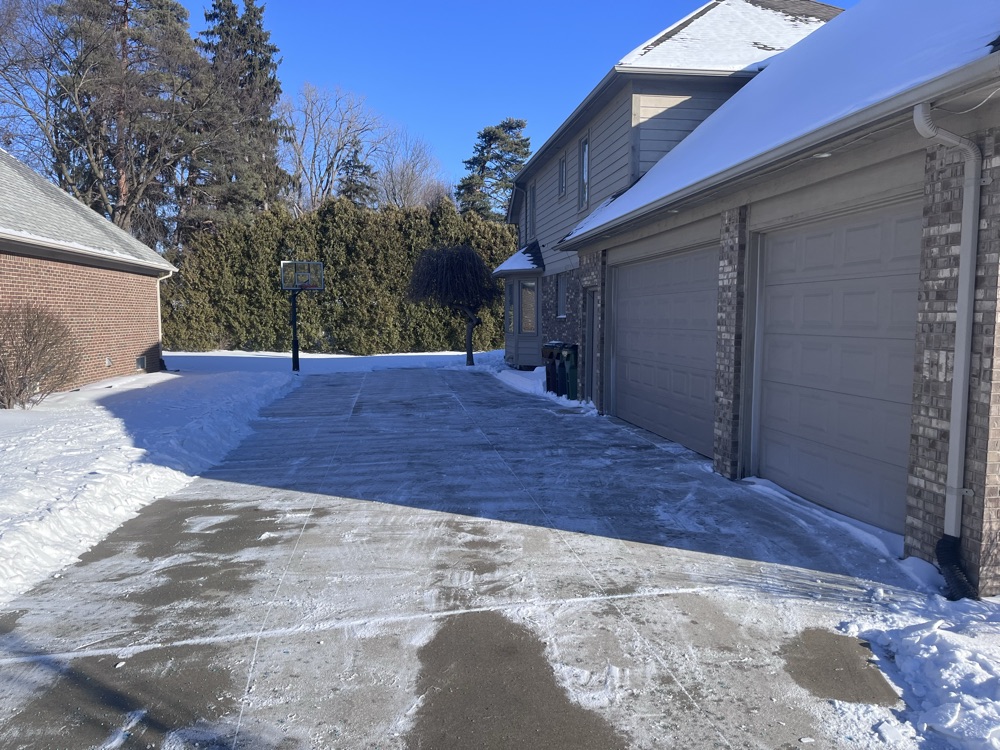 A two-car driveway cleared edge to edge after a snowfall in Macomb County